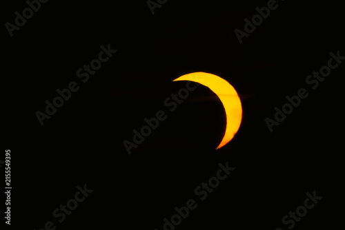 Fotografía Orange solar eclipse crescent in the dark sky, astronomical phenomenon, totality