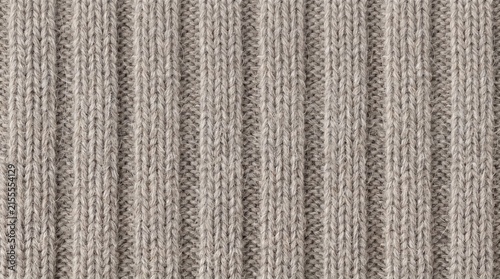 Ribbed knit fabric displays vertical corded lines and warm grey wool texture.