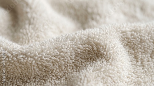 Terry cloth towel fabric showcases soft plush pile texture and subtle warm folds.