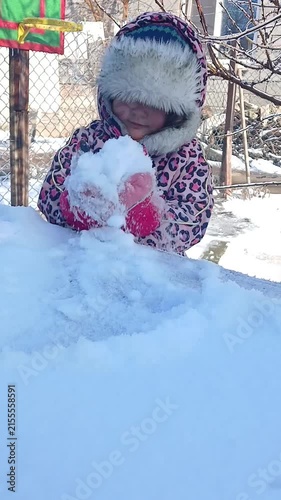 Child shoveling snow with his hands - video replay
