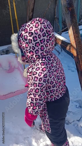Child draws with an icicle in the snow