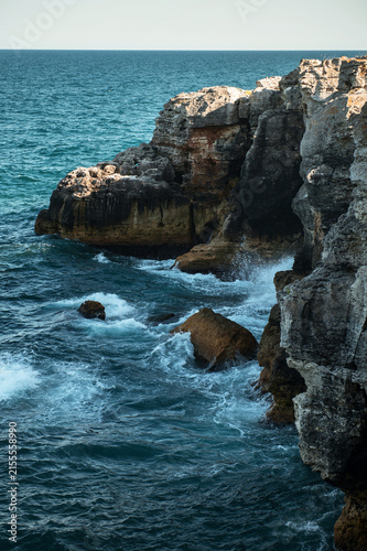 Scenic rocky coastline with turquoise sea water, cliff and rocks on a sunny day