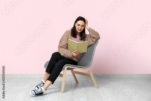 Young woman sitting on armc...