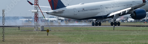 Close-up of  passenger aircraft touching down at Amsterdam Schiphol with runway tire smoke and heat haze