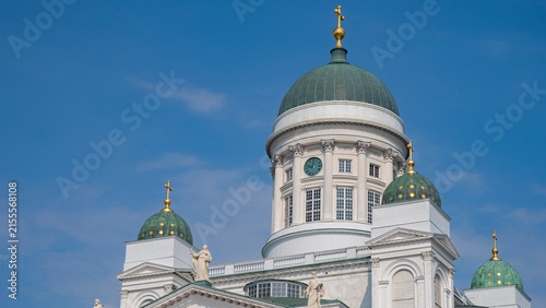 фотографія Close up of Helsinki Cathedral green domes with clock and blue sky copy space
