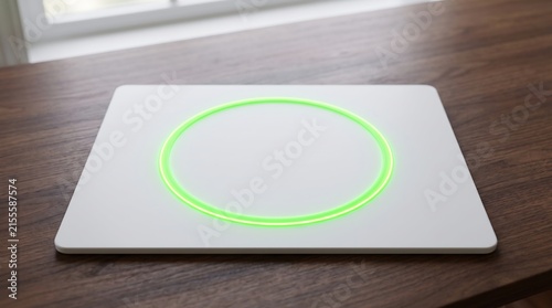Minimalist white wireless charger with glowing green LED circle on a wooden table