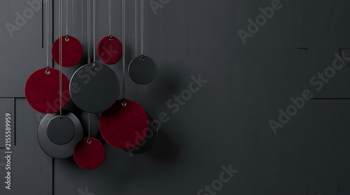 Modern abstract art composition with hanging red and black circles on textured dark wall background