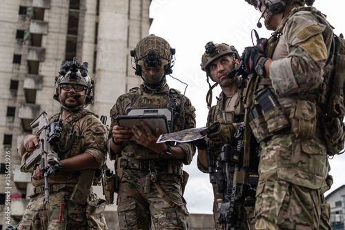 Foto Military special force team using digital tablet and paper map for tactical urba