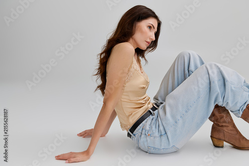 Картината върху платно Beautiful young woman poses gracefully against a bright backdrop while showcasin