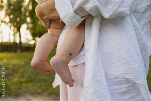 Canvastavla Close-up of a baby's legs and feet held by a parent in soft, natural light