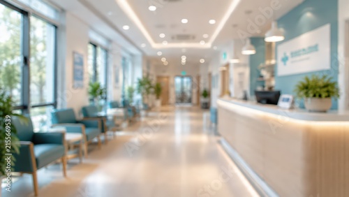 blurred interior of a modern medical clinic reception area, teal upholstered chairs, light wood counter, bright natural light through windows.
