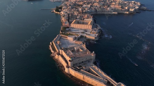 Syracuse, Italy. Aerial of Ancient city on Sicily island, Maniace Castle surrounded by Mediterranean Sea at Sunset.