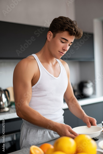 Young man preparing food in a modern kitchen, perfect for home cooking, healthy meals, and fit lifestyle concepts