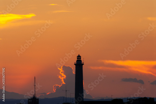 Faro silhouette al tramonto con cielo arancione infuocato