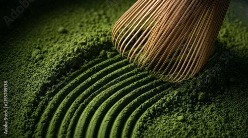 Macro shot of bamboo whisk creating curved zen lines in vibrant green matcha powder