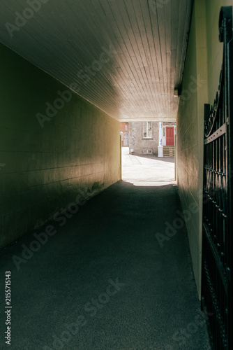 фотографія Dark passage leading to sunny interior courtyard with old houses, Quebec City, Q
