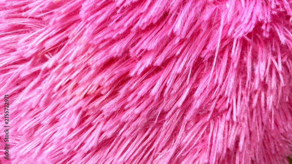 Fototapeta premium Bright pink fluffy faux fur texture with diagonal shaggy pile