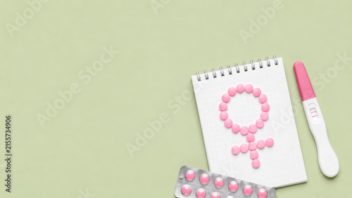 Pregnancy test with pink pills and female symbol for fertility reproductive health treatment and womens family planning.