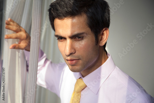 Close-up of handsome young businessman thinking at work 