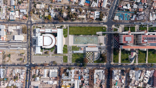Aerial view of Bicentennial square featuring modern civic center buildings, a large rectangular reflecting pool, manicured lawns, and surrounding urban grid in San Juan, San Juan, Argentina.