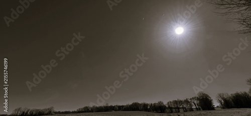 Photography A wide field stretches beneath a bright sky, captured in black and white