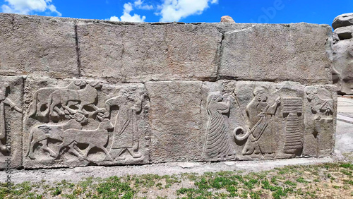 Obraz na plátne Ancient Hittite orthostat relief wall depicting a chariot wheel, lute players, and acrobats at the Alacahöyük archaeological site, Turkey