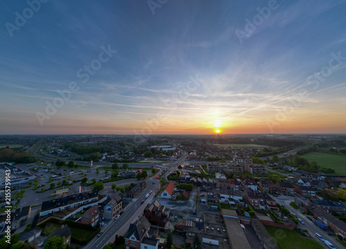 Lier, Antwerp, Belgium, 28th of April, 2025, A stunning sunset casts warm hues over the city, illuminating roads and buildings with a gentle glow