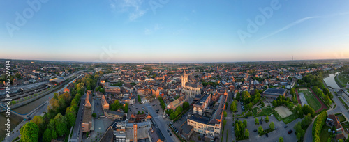 Halle, Vlaams Brabant, Belgium, 27th of April, 2025, Captivating aerial panorama showcasing a vast cityscape beautifully illuminated by the enchanting golden hour light