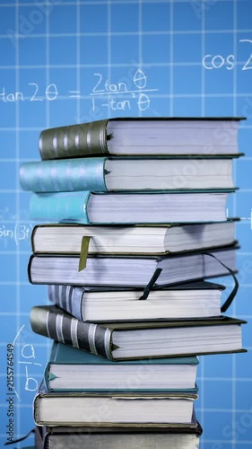 Pile of books and mathematical equations and graphs