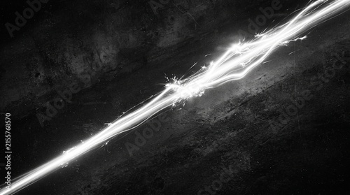 Bright white light streak moving across a dark black background creating a fast motion blur effect