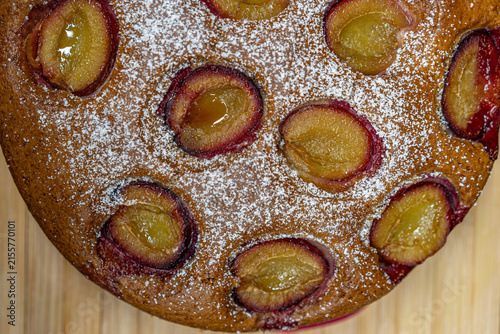 Cuadro en lienzo Top view of homemade plum cake sprinkled with powdered sugar