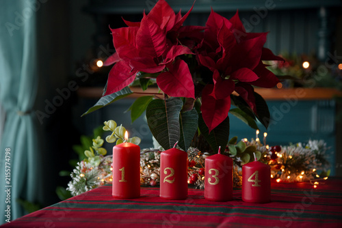 Advent Candles and Poinsettia Christmas Decoration on Festive Table