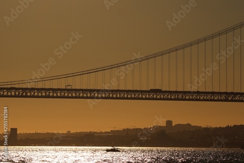 Foto Lisbon, Portugal - August 12, 2026: Crowds in eclipse glasses watch a partial solar eclipse at sunset near the 25 de Abril Bridge and Praça do Comércio