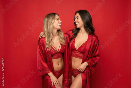 Two Women In Vibrant Lingerie Smiling And Laughing During Artistic Photoshoot Session