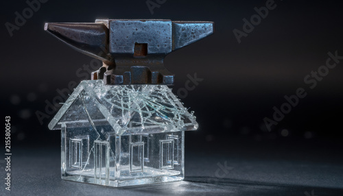 Glass house anvil fragile heavy clear cracked pressure risk damage contrast macro shot of clear glass house crushed by heavy metal anvil, dark background, stress concept