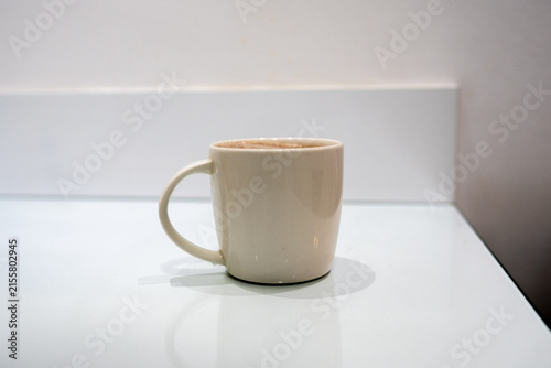 Ceramic coffee cup with hot drink on clean minimal surface cacao