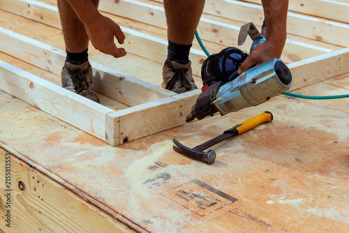Obraz na płótnie Construction worker builds wooden frame on construction site using tools materia