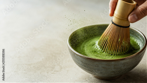 Fotografía Hand whisking matcha tea in ceramic bowl with bamboo chasen