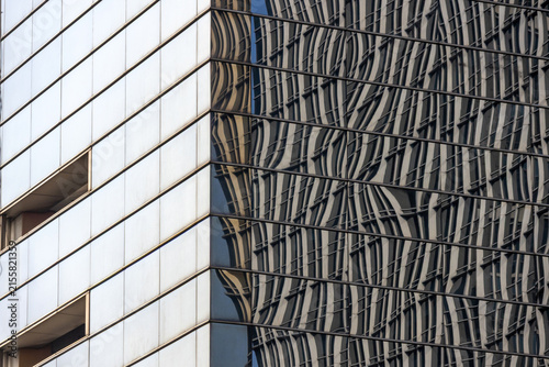 Glass facade of a Jakarta building reflects the surrounding cityscape