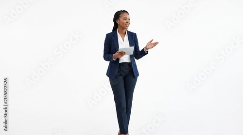 Confident Businesswoman Presenting: A poised African businesswoman in a sharp navy suit stands confidently, tablet in hand, gesturing as she presents her ideas.