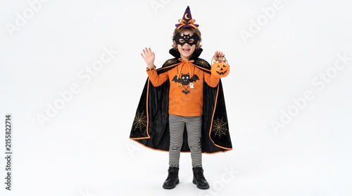 Spooky Spectacle: A young child dressed in a vibrant witch costume, complete with a pointed hat, cape, and festive candy bucket, joyfully celebrates Halloween.