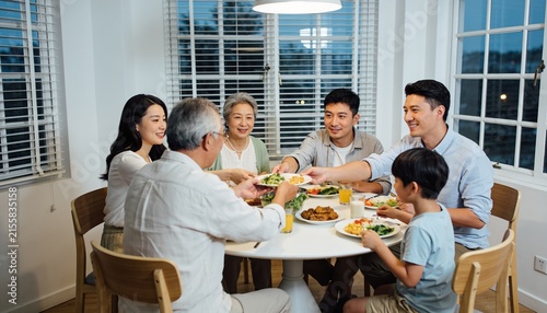 Happy multi-generational Asian family sharing a meal at a round table during dinner, family bonding and togetherness for domestic lifestyle and healthy eating at home