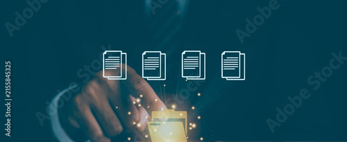 Hand taps glowing screen with four document icons. Fingers press with purpose, sparks suggest digital action. Modern interface implies efficiency and tech-savvy workflow. Ideal for business, education