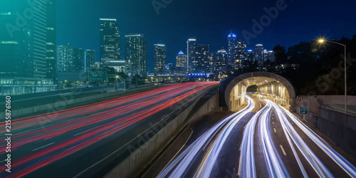Long exposure night traffic on metropolitan highway interchange with exposure transportation downtown metropolis infrastructure vehicles velocity movement skyscrapers architecture nighttime
