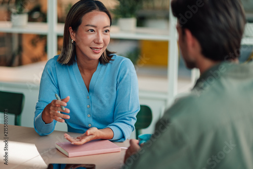 Woman discussing and collaborating on a project with a male coworker in a modern office