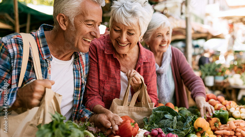 Happy senior friends shopping for fresh vegetables at an outdoor farmers market
