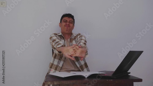 Joyful Student Celebrating Accomplishment with Clear Laptop and Study Materials on Desk