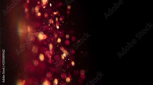 Red and gold glowing bokeh particles on black background