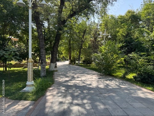 Scenic view of lush green trees, landscaped gardens, and clean walking paths inside a public park in Ashgabat, Turkmenistan