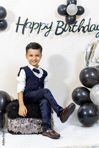 confident Child in Bow Tie and Waistcoat Enjoying a Stylish Indoor Birthday Celebration